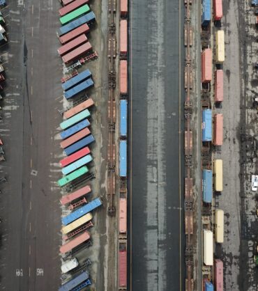 Profesjonalna flota ciężarowa w trakcie załadunku towaru w centrum logistycznym